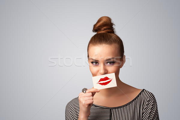 Happy pretty woman holding card with kiss lipstick mark Stock photo © ra2studio