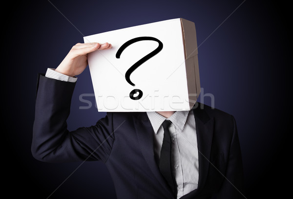 Stock photo: Businessman gesturing with a cardboard box on his head with ques