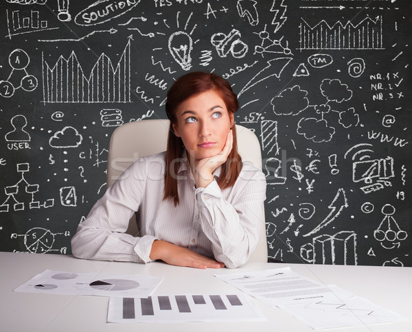 Businesswoman sitting at desk with business scheme and icons Stock photo © ra2studio