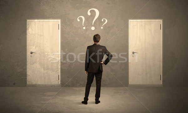 Businessman standing in front of doors Stock photo © ra2studio