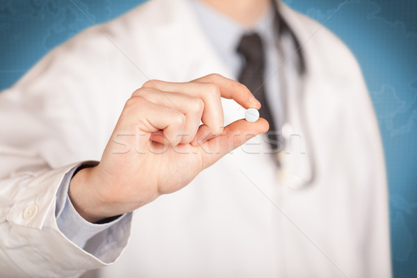 Doctor in white holding a pill Stock photo © ra2studio