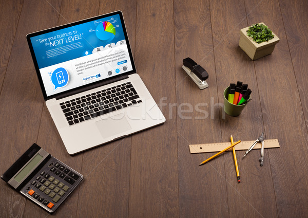 Laptop on office desk with business website on screen Stock photo © ra2studio