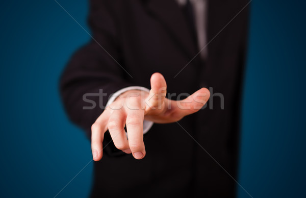 Businessman pressing imaginary button Stock photo © ra2studio