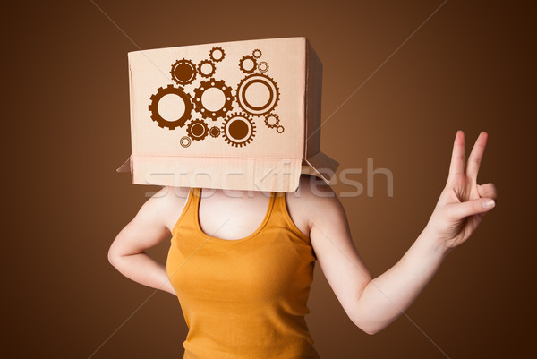 Young woman gesturing with a cardboard box on his head with spur Stock photo © ra2studio