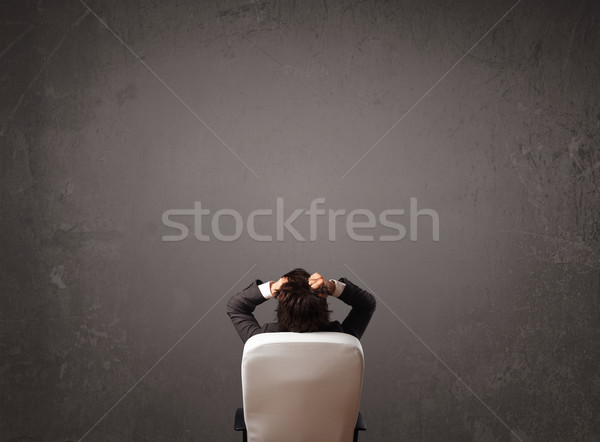 Businessman sitting in front of a wall with copy space Stock photo © ra2studio