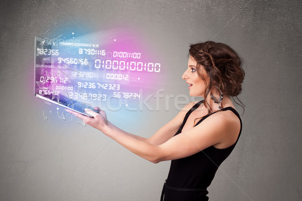 Casual woman holding laptop with exploding data and numers Stock photo © ra2studio