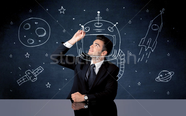 Sales person drawing helmet and space rocket Stock photo © ra2studio