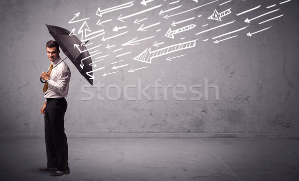 Business man standing with umbrella and drawn arrows hitting him Stock photo © ra2studio