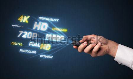 Hand with remote control and multimedia properties Stock photo © ra2studio
