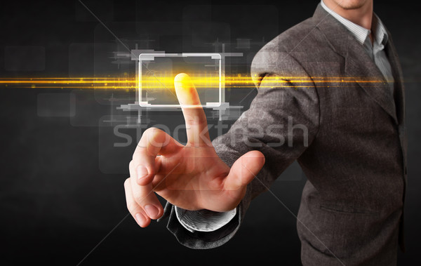 Tech business person touching button with orange light beams con Stock photo © ra2studio