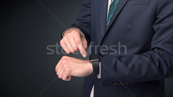 Man in suit wearing smartwatch. Stock photo © ra2studio