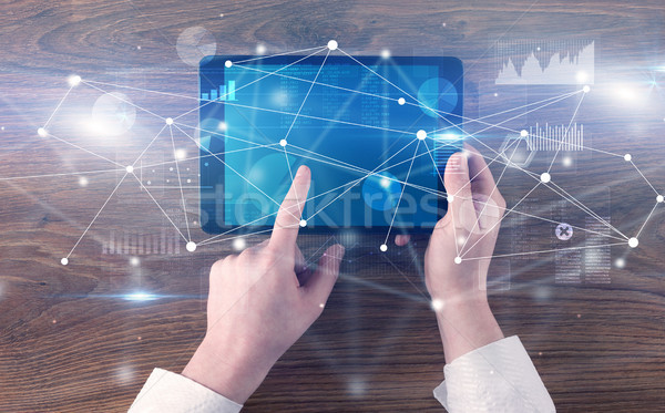 Hand holding tablet with linked graphs and charts concept Stock photo © ra2studio