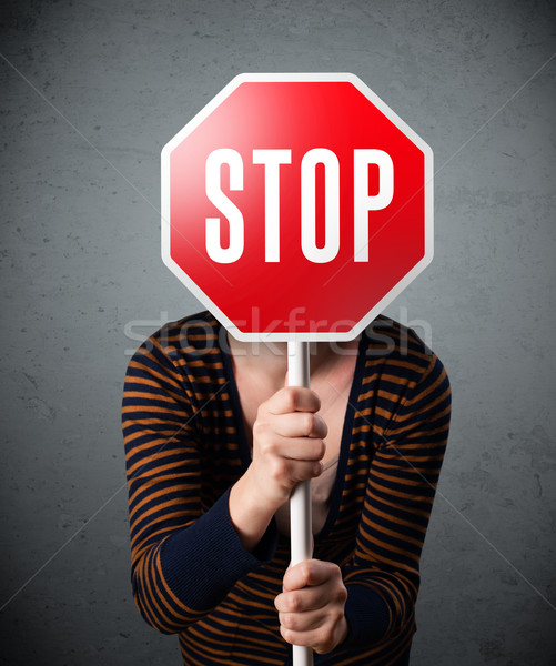 Stock photo: Young woman holding a stop sign