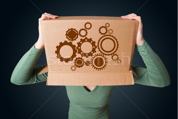 Young woman gesturing with a cardboard box on his head with spur Stock photo © ra2studio
