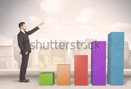Stock photo: Business person climbing up on colourful chart pillars concept