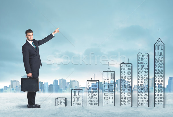 Business man climbing up on hand drawn buildings in city Stock photo © ra2studio