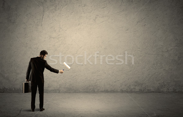 Salesman with roller standing at empty wall Stock photo © ra2studio