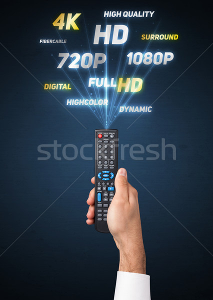 Hand with remote control and multimedia properties Stock photo © ra2studio