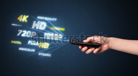 Hand with remote control and multimedia properties Stock photo © ra2studio