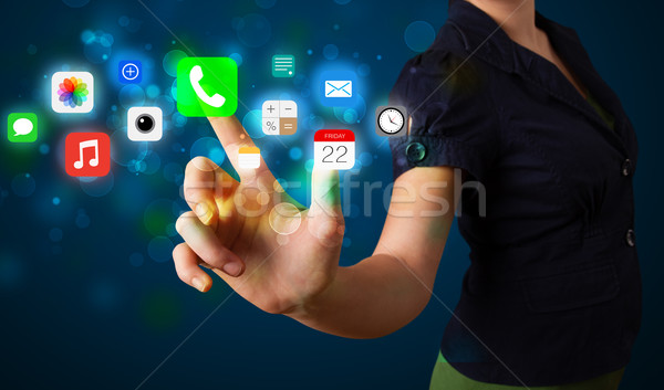Young businesswoman pressing colorful mobile app icons with boke Stock photo © ra2studio