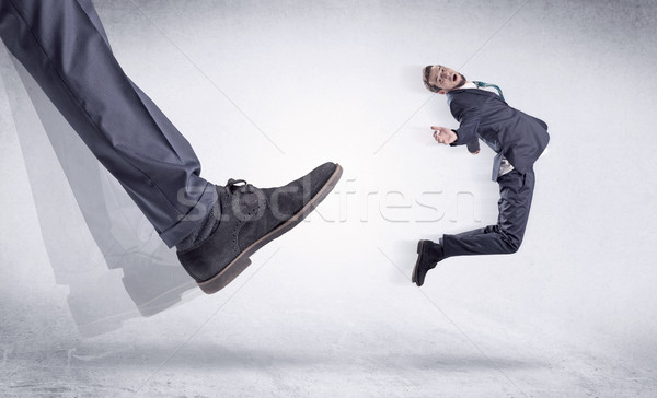 Stock photo: Black shoe kicking small man