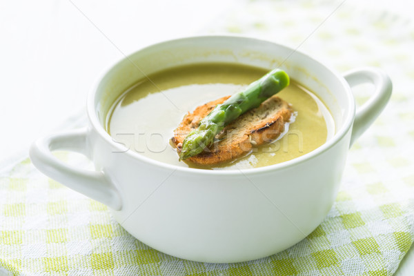 Asparagus soup in a white bowl with slice of bread and asparagus Stock photo © rafalstachura