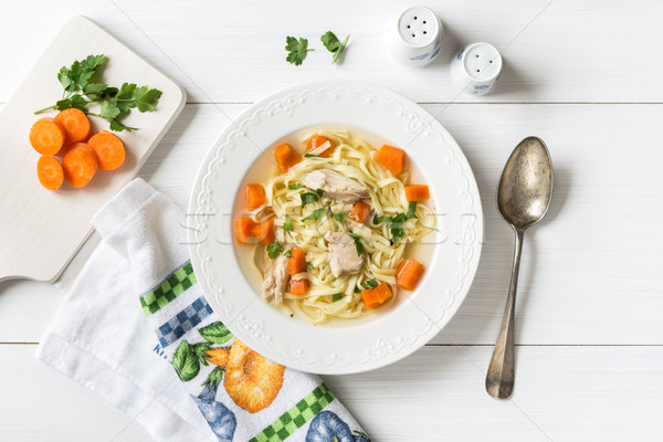 Top view of chicken soup with pasta, carrot and parsley on white Stock photo © rafalstachura