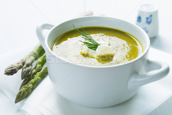 Bowl of asparagus soup topped with fresh cream and dill Stock photo © rafalstachura