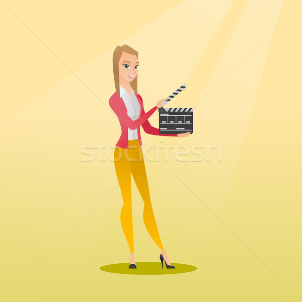 Smiling woman holding an open clapperboard. Stock photo © RAStudio