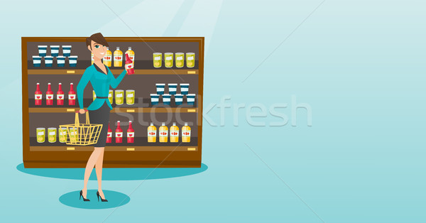 Woman holding shopping basket and bottle of sauce. Stock photo © RAStudio