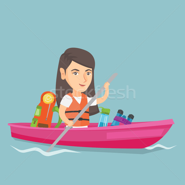 Stock photo: Young caucasian woman riding a kayak.