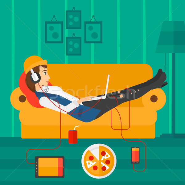 Woman lying on sofa with many gadgets. Stock photo © RAStudio