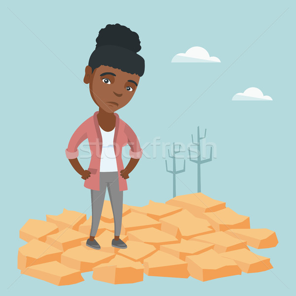 Stock photo: Sad woman standing on cracked earth in the desert.