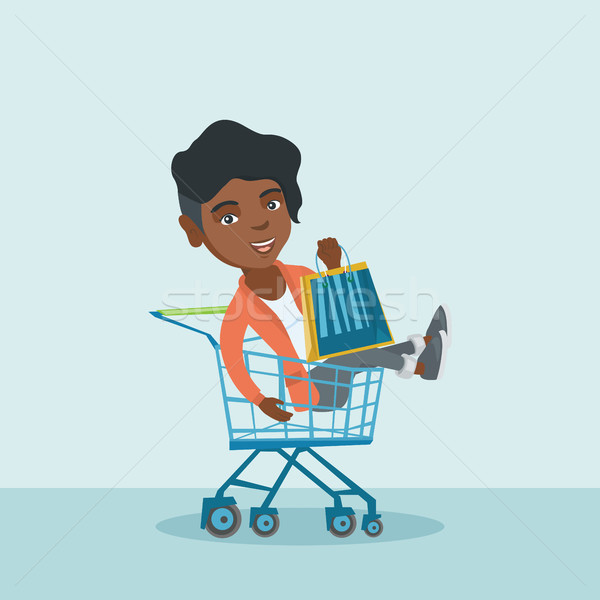 Young african woman riding in shopping cart. Stock photo © RAStudio