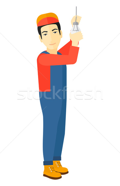 Electrician twisting light bulb. Stock photo © RAStudio