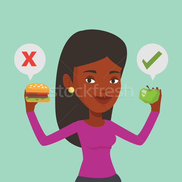 Stock photo: Woman choosing between hamburger and cupcake.