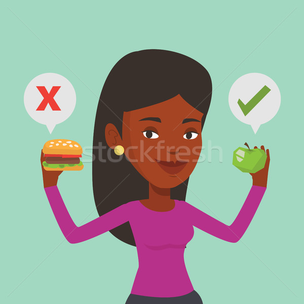 Woman choosing between hamburger and cupcake. Stock photo © RAStudio