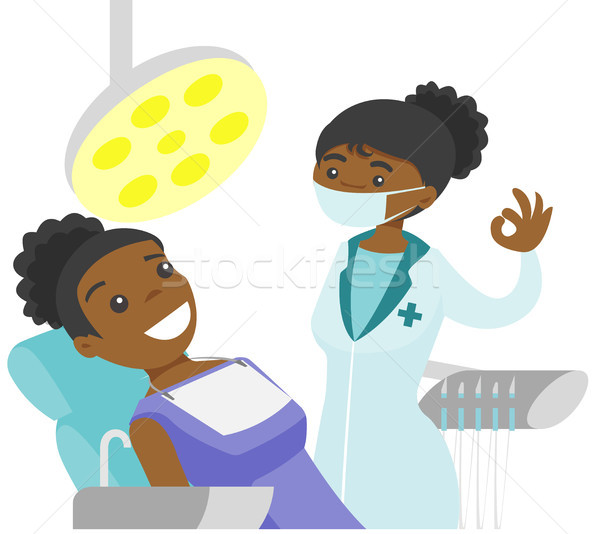 Dentist standing next to the chair with patient. Stock photo © RAStudio