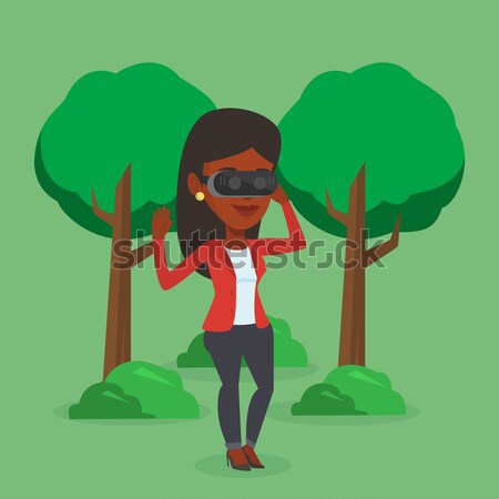 Woman wearing virtual reality headset in the park. Stock photo © RAStudio