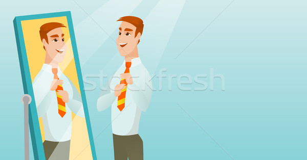 Stock photo: Business man looking himself in the mirror.