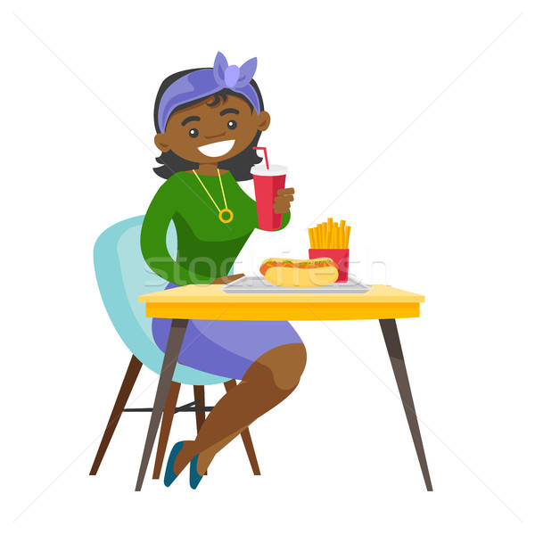 Tineri femeie mananca fast food şedinţei tabel Imagine de stoc © RAStudio