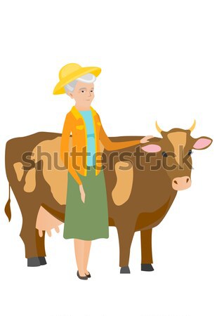 Farmer standing with crossed arms near cow. Stock photo © RAStudio