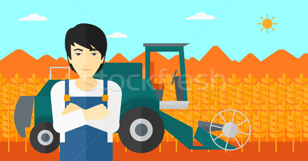 Stock photo: Man standing with combine on background.