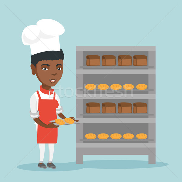 Young african baker holding a tray with bread. Stock photo © RAStudio