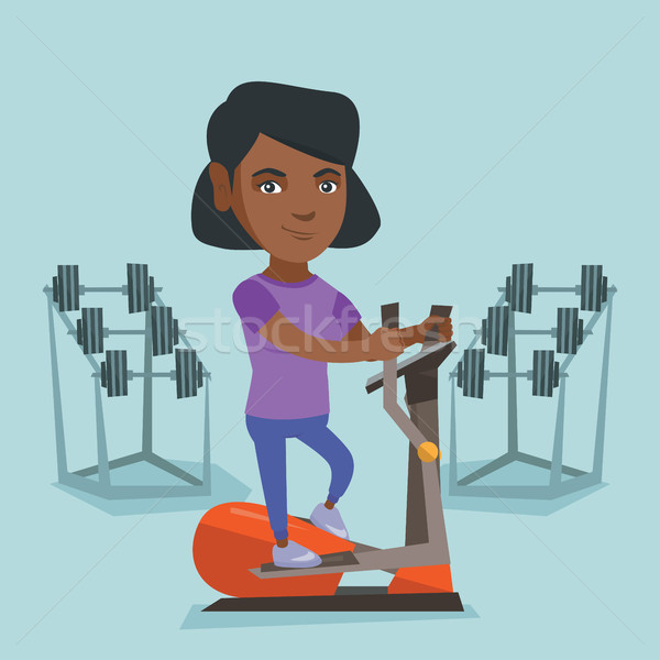 African woman exercising on elliptical trainer. Stock photo © RAStudio
