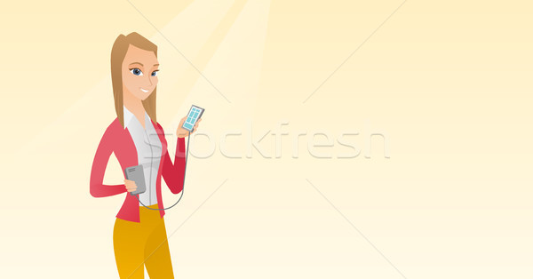 Woman reharging smartphone from portable battery. Stock photo © RAStudio