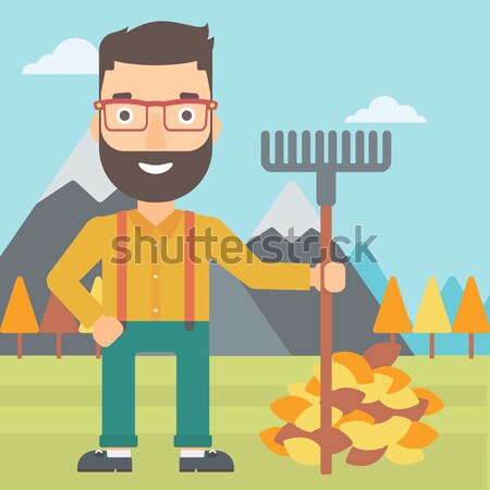 Stock foto: Mann · Rake · stehen · Heap · Herbstlaub · Hipster