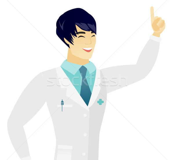 Young asian doctor pointing with his forefinger. Stock photo © RAStudio
