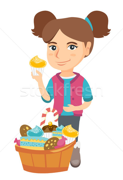 Girl holding a cupcake and stroking her belly. Stock photo © RAStudio