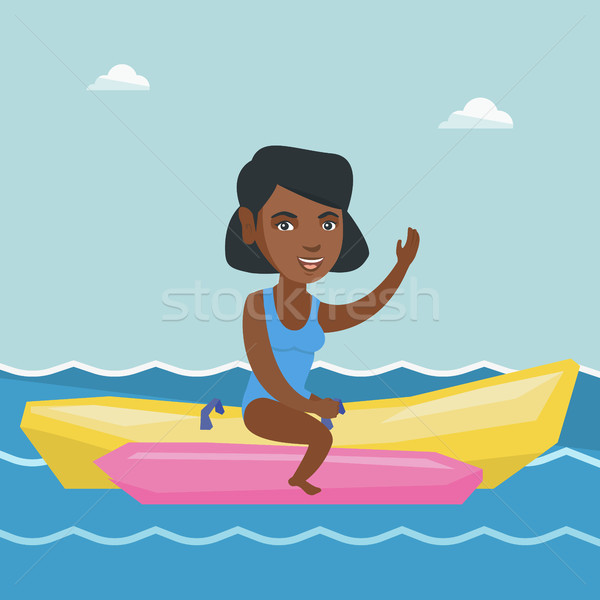 Young african-american woman riding a banana boat. Stock photo © RAStudio